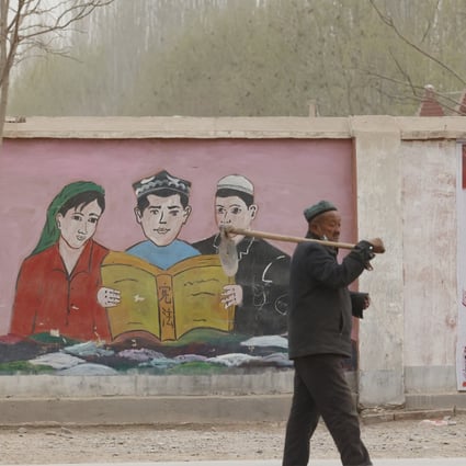 Government posters depict ethnic minority residents reading the constitution, near Kashgar in Xinjiang. Photo: AP  