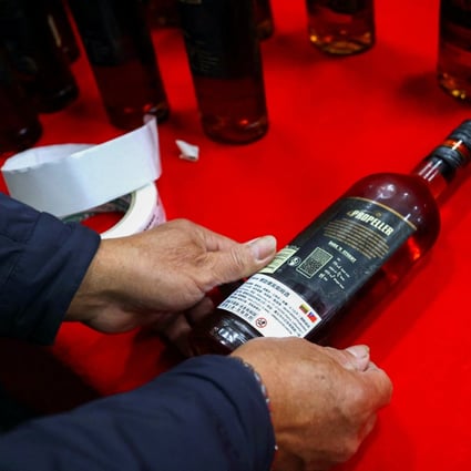 A staff member of Taiwan Tobacco and Liquor Corporation covers a simplified Chinese label with a traditional Chinese label on a bottle of rum from Lithuania at a cargo storage area, in Taoyuan, Taiwan, on January 22. Photo: Reuters 