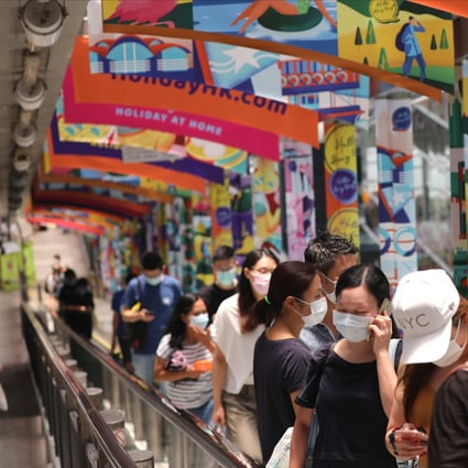 People in masks stand on the Mid-Levels escalator in Central in 2020. Photo: Nora Tam 