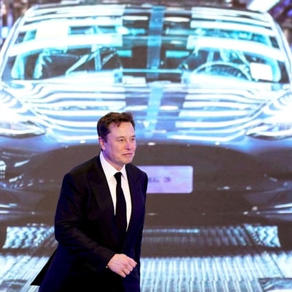 Tesla’s chief executive Elon Musk in front of a screen showing a Tesla Model 3 car. Photo: Reuters.