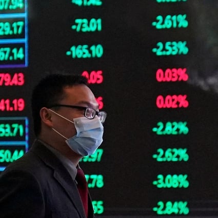 A man walking past an electronic board inside the Shanghai Stock Exchange building in February 2020. Photo: Reuters