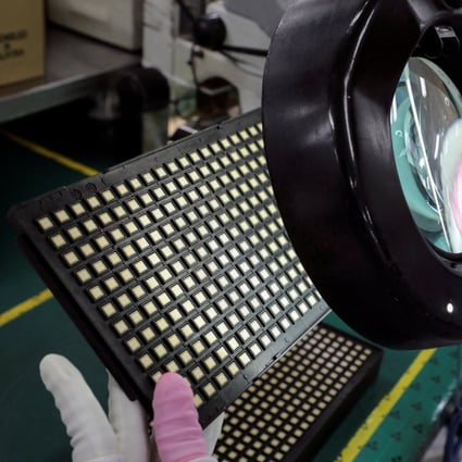 A worker inspects semiconductor chips at a chip packaging firm. Photo: Reuters   
