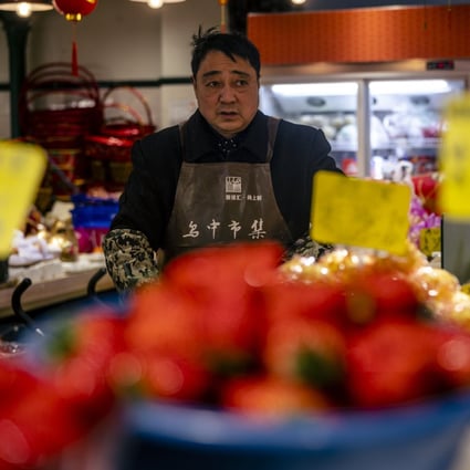 A man sells food in a wet market in Shanghai on January 11. China has a long history of high inflation and the recent two decades of low inflation is really an aberration. Photo: EPA-EFE 