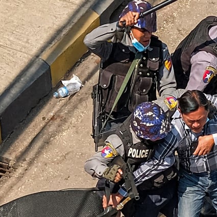Police arrest a man in Taunggyi, Myanmar on February 28, 2021, as security forces continue to crackdown on demonstrations by protesters against the military coup. (Photo by AFP)