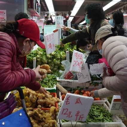 People buy vegetables and fruit at a wet market in North Point on February 8. Vegetable supplies in Hong Kong have been tight because of transport disruptions at the mainland border. Photo: Sam Tsang