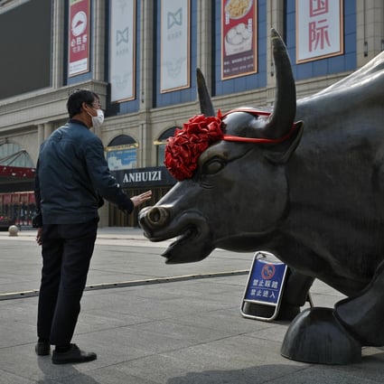 A man touches the bull statue outside a shopping mall in Beijing last year. Photo: AP