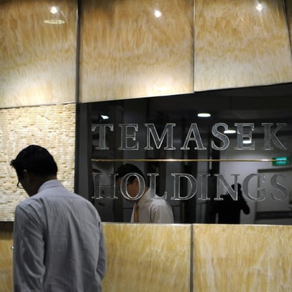 A man walks past the Temasek signboard outside its head office in Singapore. Photo: AFP