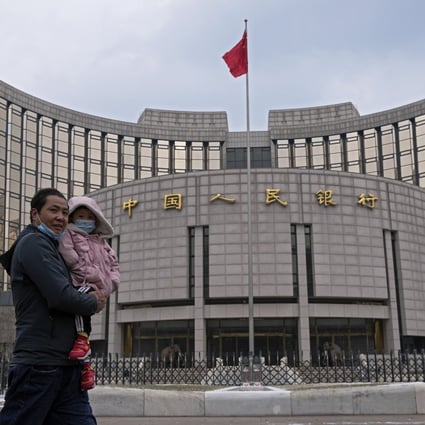 A man carries a child in front of China’s central bank in Beijing on January 20. The cautionary mood in the market makes sense when underlying demand from the private sector remains subdued. Photo: AP