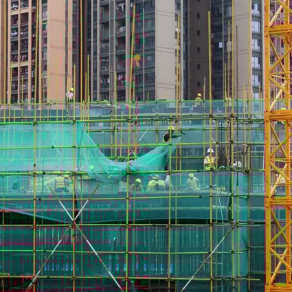 Workers on the scaffoldings of a construction site near residential buildings in Shenzhen on May 17, 2020. Photo: Reuters.
