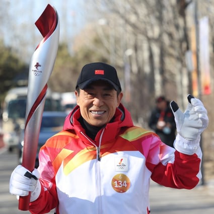 Zhang Yimou runs with the Olympic torch in Beijing. Photo: Xinhua