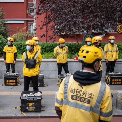 Food delivery couriers for Meituan stand with insulated bags during a morning briefing in Beijing, April 21, 2021. Photo: Bloomberg