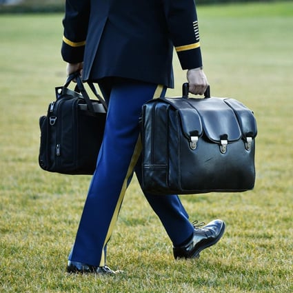A military aide carries the “nuclear football”, containing nuclear launch codes, as outgoing US president Donald Trump departs from the South Lawn of the White House on January 20, 2021. Photo: AFP  