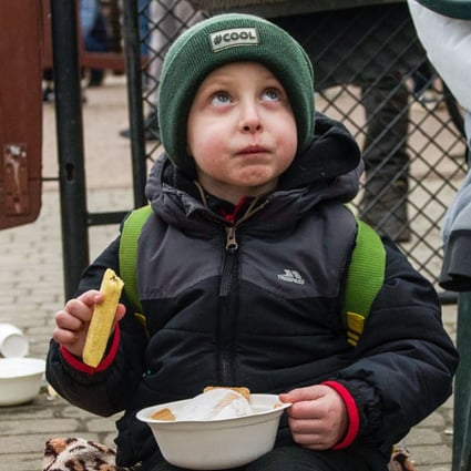 A refugee child eats at the food distribution point at the border crossing in Medyka, Poland on Friday. Photo: dpa