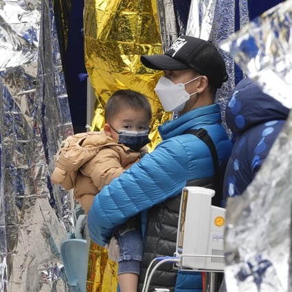 A man and child wait at a temporary treatment area outside a hospital on February 18. Since the start of the pandemic, Hong Kong has maintained a policy of isolating and hospitalising all positive cases, regardless of age, leading to fears of family separation. Photo: AP