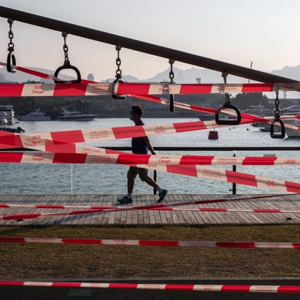 A pedestrian passes barrier tape cordoning off a gym facility, closed due to Covid-19 restrictions, at the Kwun Tong Promenade in Hong Kong on March 3. Officials in the city must have the courage to do what it takes to bring the virus under control. Photo: Bloomberg