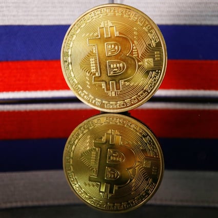 A representation of bitcoin is displayed in front of Russian flags in this picture illustration taken March 4, 2022. Photo: Reuters