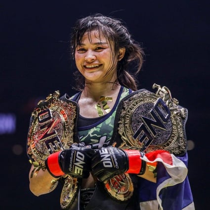 Stamp Fairtex holding the ONE atomweight Muay Thai and kickboxing belts. Photo: ONE Championship.