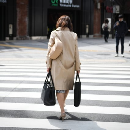 A woman crosses a street in Tokyo, Japan, on March 7. Employers often see little merit in offering jobs to women wanting to return to work in their 40s. Photo: Bloomberg