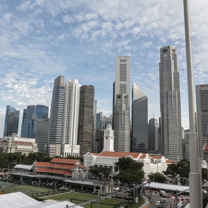 The Singapore flag flies over the National Gallery, seen against the skyline of the financial district in Singapore. Photo: EPA-EFE