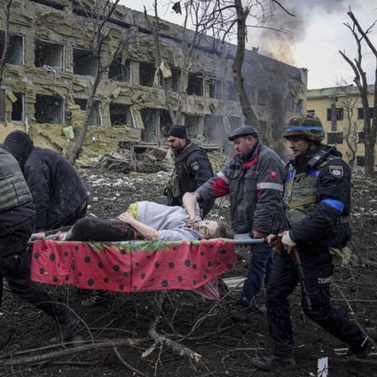 Ukrainian emergency employees and volunteers carry an injured pregnant woman from the maternity hospital, damaged by shelling, in Mariupol, Ukraine, on Wednesday. Photo: AP