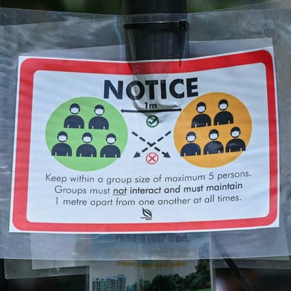 A notice warning people not to gather in groups larger than five to help stop the spread of Covid-19 is displayed at Raffles Place in Singapore in February. Photo: AFP