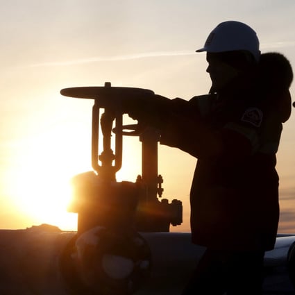 A worker checks the valve of an oil pipe the West Siberian city of Kogalym, Russia. Photo: Reuters