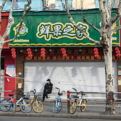 A security guard in front of closed stores at a residential neighborhood placed under lockdown due to Covid-19 in Shanghai, on Thursday, March 10, 2022. Photo: Bloomberg