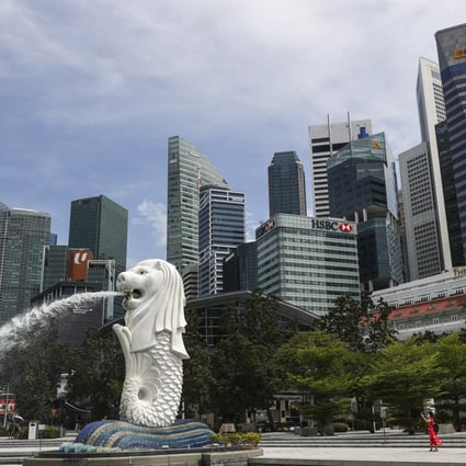 The financial skyline of Singapore is seen behind the Merlion statue in Marina Bay. Photo: AP.