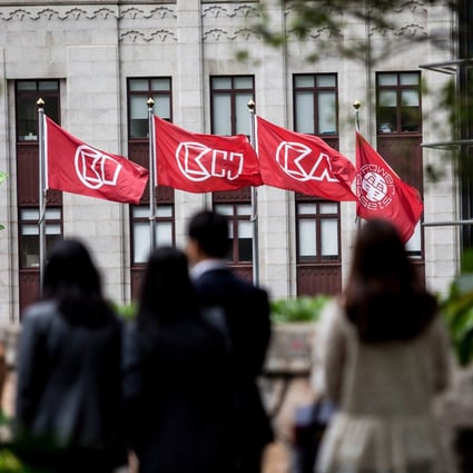 People walk before flags of CK Hutchinson Holdings outside the company’s headquarters in Hong Kong on March 21, 2019.Photo: AFP