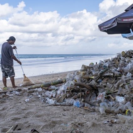 A worker cleans up piles of debris and plastic waste brought in by strong waves at Kuta Beach in Bali, Indonesia, on December 10, 2021.  Photo: EPA-EFE