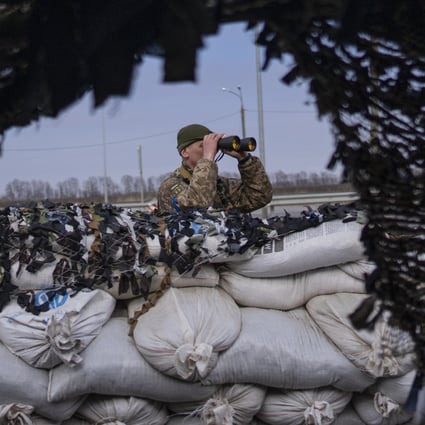 A Ukrainian soldier looks through binoculars at a military check point. Photo: AP