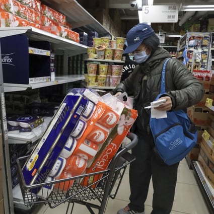 A woman stocks up on toilet paper rolls at a supermarket in Mong Kok, Hong Kong, in February 2020, as panic buying sparked by the coronavirus spreads through the city. Photo: Nora Tam