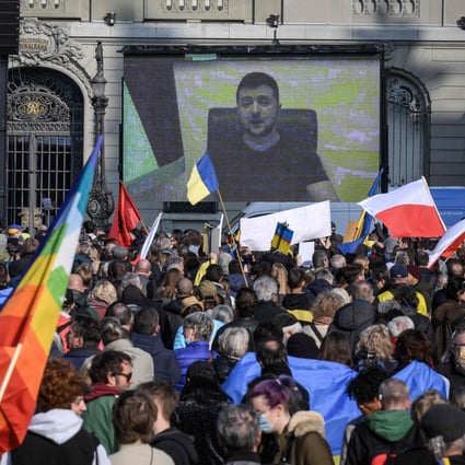 Ukrainian President Volodymyr Zelensky is displayed on a giant screen after delivering a live voice message during a demonstration against the Russian invasion of Ukraine in front of the Swiss House of Parliament in Bern, Switzerland on March 19. Photo: AFP