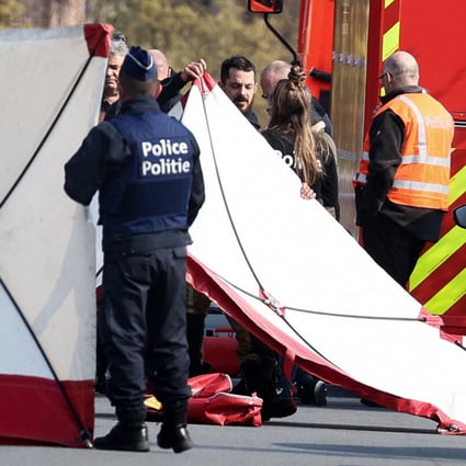 Police erect a white sheet where a car crashed into the crowd. Photo: AFP