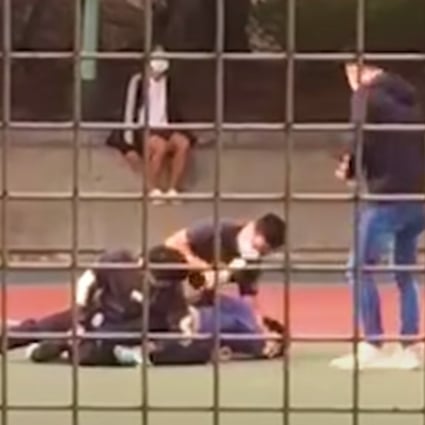 A still from a video posted online shows a 15-year-old boy being subdued by plain-clothes police officers after being caught with his 13-year-old brother playing basketball without wearing face masks on March 8. Photo: YouTube