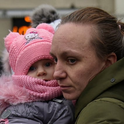 A woman holds her children as civilians fleeing Russia’s invasion of Ukraine wait to board an evacuation train in Odesa on March 16. Photo: Reuters