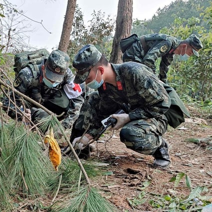 Police officers search the site of the China Eastern Airlines plane crash in southern Guangxi province. Photo: CNS