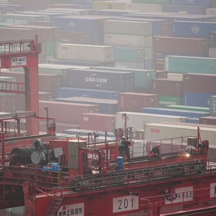Workers near containers at the Yangshan Deep Water Port in Shanghai in January 2022. Photo: Reuters