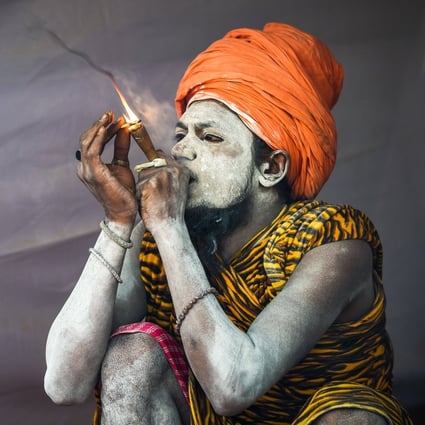 An Indian sadhu smokes inside his tent at the Kumbh Mela festival in Allahabad. Photo: AFP