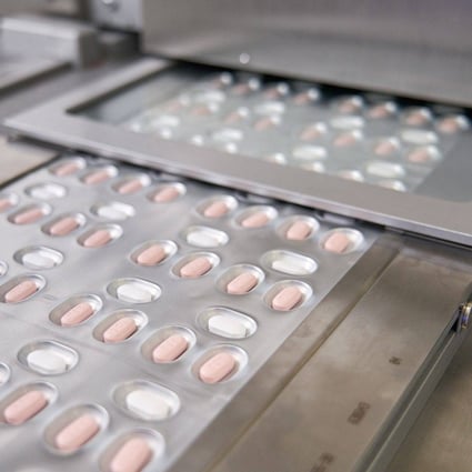 Courses of Pfizer’s anti-Covid drug Paxlovid roll off of a production line in Germany. Photo: AFP