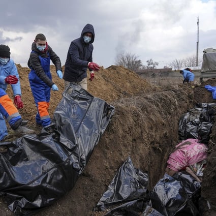 Dead bodies are placed into a mass grave on the outskirts of Mariupol. Photo: AP 