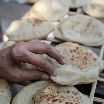 A woman checks bread in Cairo. In Egypt, bread is a staple food for tens of millions and soaring prices have sparked serious unrest in the past. Photo: Reuters