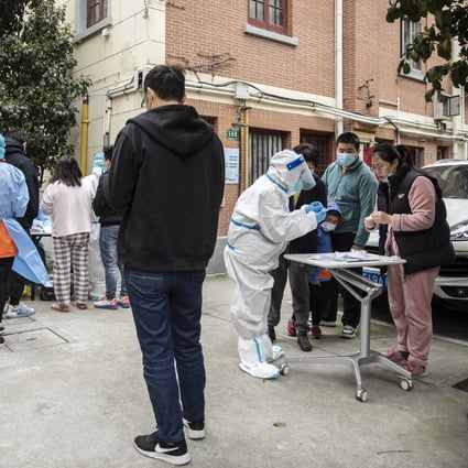 Residents gather to receive rapid antigen test kits for Covid-19 at a neighbourhood in Shanghai on Saturday. Photo: Bloomberg