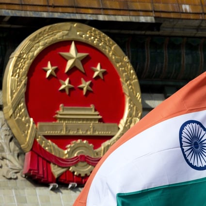 An Indian national flag is flown next to the Chinese national emblem in Beijing. Photo: AP