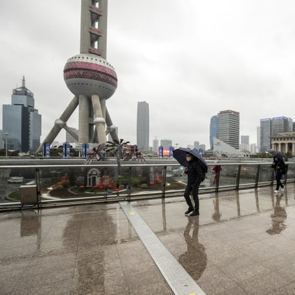 Pedestrians pass buildings in Pudong’s Lujiazui dinancial district in Shanghai in February 2022. Photo: Bloomberg