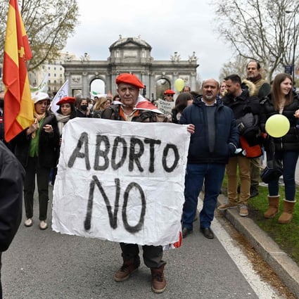 A protester wearing a Carlist red beret holds a banner during a demonstration protesting against abortion in Madrid, Spain on March 27. Photo: AFP