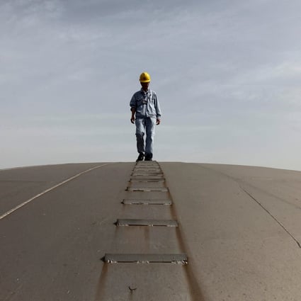An employee walks on top of an oil tank at a Sinopec refinery in Wuhan in this file photo from April 2012. The refiner says it will pay 80 per cent of its 2021 profits to shareholders through dividend. Photo: Reuters