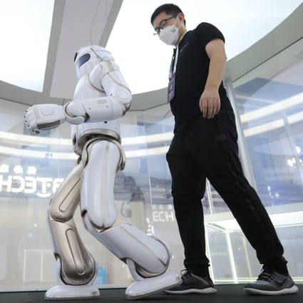 A man walks with a robot at the 2021 World Robot Conference in Beijing. Photo: Simon Song