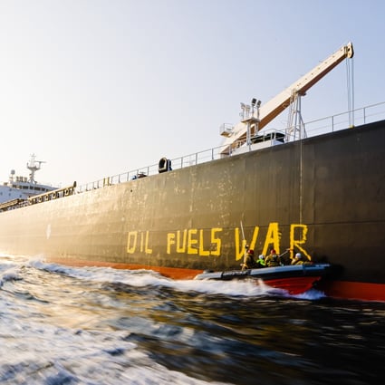 Activists from environmental organisation Greenpeace paint the words “Oil fuels war” on the hull of a ship carrying Russian oil in the Baltic Sea. Photo: Frank Molter/dpa