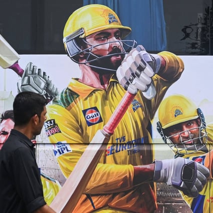 A pedestrian walks past an image depicting Indian cricketer Ravindra Jadeja, who will captain the Chennai Super Kings in this season’s IPL. Photo: AFP